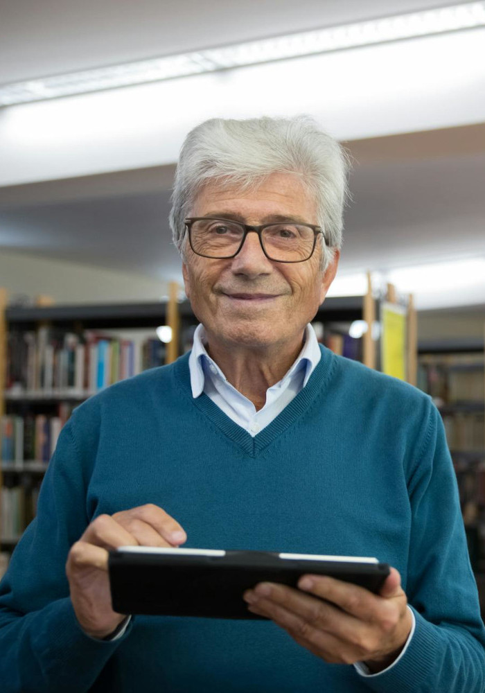 Persona mayor utilizando tecnología HumanWare para lectura